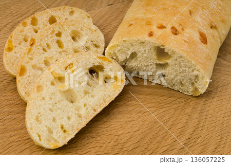 Ciabatta - Italian bread with cheese cut into slices on a wooden board 136057225