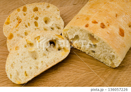 Ciabatta - Italian bread with cheese cut into slices on a wooden board 136057226