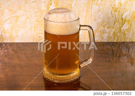 Glass with amazing beer and foam on top of the table 136057302