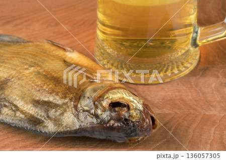 stockfish and glass of beer on a wooden board 136057305