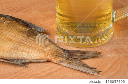 stockfish and glass of beer on a wooden board 136057306
