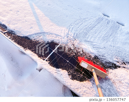 Clean snow off solar panels with a broom 136057747