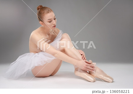 Captivating ballet dancer gracefully preparing for performance 136058221