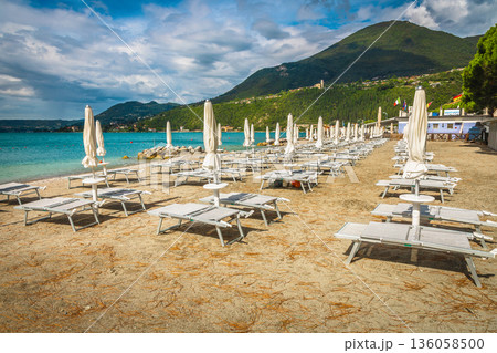 Stunning beach with white parasols in row, Lake Garda, Italy 136058500
