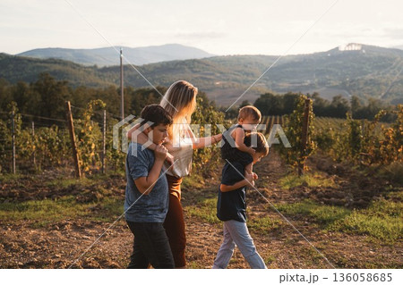 Mother Walking with Her Three Children in Vineyard Mother Walking with Her Three Children in Vineyard 136058685