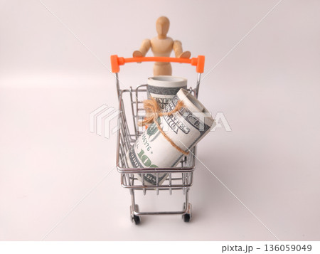 Shopping cart toy with a wooden artist's figure pushing it, and a roll of US currency inside. Shopping cart toy with a wooden artist's figure pushing it, and a roll of US currency inside. 136059049