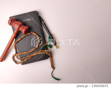 Wooden gavel, prayer beads (tasbih), and a notebook,represent the concept of Islamic law or Sharia. Wooden gavel, prayer beads (tasbih), and a notebook,represent the concept of Islamic law or Sharia. 136059072