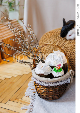 Easter basket with kulich cakes and white bunnies on cozy spring background Easter basket with kulich cakes and white bunnies on cozy spring background 136059286