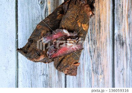 Slices of dried beef meat on wooden board surface after being prepared for snacks in kitchen 136059316