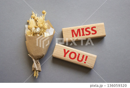 Miss you symbol. Concept word Miss you on wooden blocks. Beautiful grey background with bouquet of flowers. Business and Miss you concept. Copy space 136059320