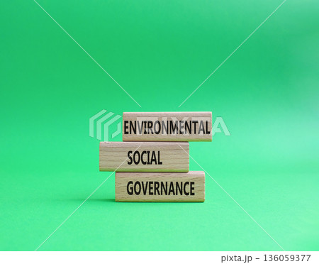 Wooden blocks displaying the words Environmental, Social, and Governance on a vibrant green background, representing the concept of sustainable business practices and corporate responsibility. Copy 136059377