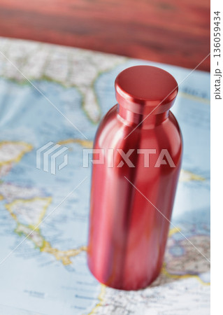 Red water bottle and paper map 136059434