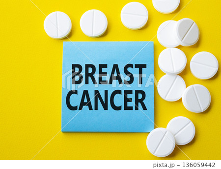 Breast cancer symbol. Concept word Breast cancer on blue note. Beautiful yellow background with pills. Medicine and Breast cancer concept. Copy space 136059442