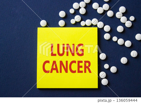 Lung Cancer symbol. Concept word Lung Cancer on yellow note. Beautiful deep blue background with pills. Medicine and Lung Cancer concept. Copy space 136059444