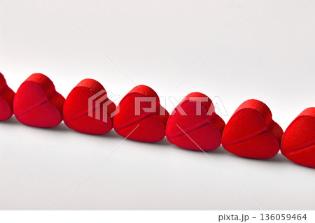 Red heart-shaped gummy candies close-up lined up on white background, selective focus Red heart-shaped gummy candies close-up lined up on white background, selective focus 136059464