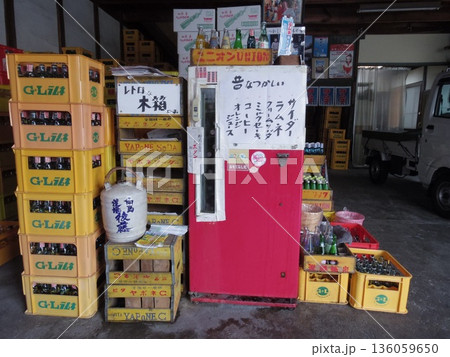 古い冷蔵庫と木箱があるジュース販売所 136059650