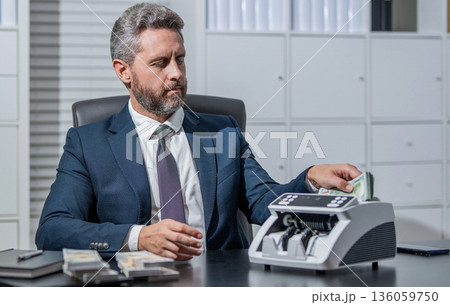Money counting machine. Economic wealth and value investing. Electronic money counter machine counting dollar banknote. Finance and business. Bank officer counting dollar with machine at bank office 136059750