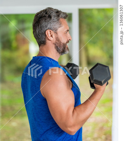 Sport athlete man with dumbbell. Healthy lifestyle. Biceps muscle. Strong triceps. Man exercising with dumbbell. Man athlete lifting dumbbell. Strong man do sport exercise. Gym workout shoulder press 136061307