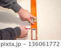 Hands Using Spirit Level Tool for Wall Alignment 136061772