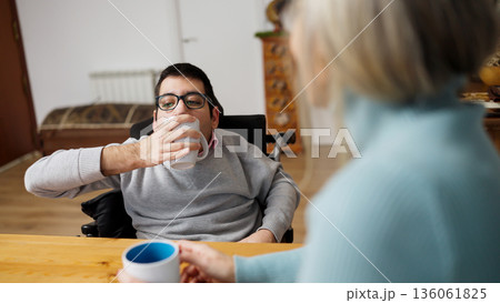 Man living with a condition enjoying coffee with friend 136061825