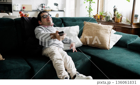 Man with physical condition watching television at home Man with physical condition watching television at home 136061831