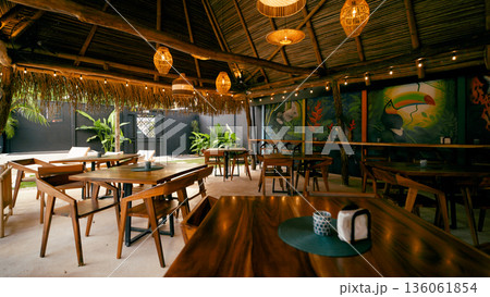 Tropical restaurant decor with thatched roof and jungle mural 136061854