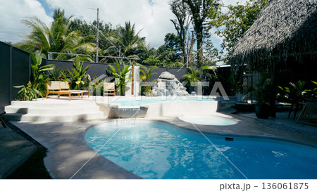 Tropical swimming pool with waterfall resort vacation area Tropical swimming pool with waterfall resort vacation area 136061875