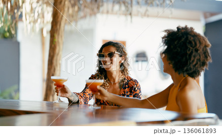 Women enjoying cocktails at an outdoor bar Women enjoying cocktails at an outdoor bar 136061893