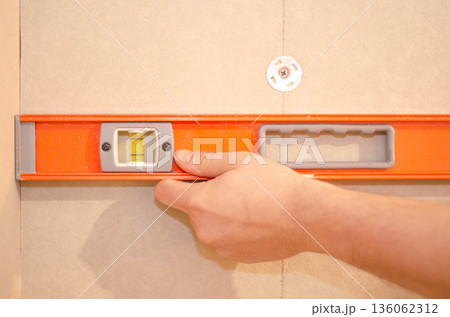 Checking Wall Alignment with Spirit Level 136062312