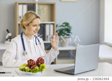 Online dietitian consultation from medical office with laptop and fresh produce 136062484