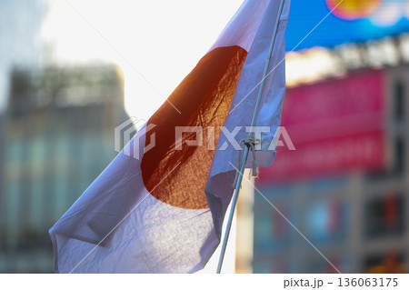 【日本の国旗】冬の空の街並みになびく国旗 136063175