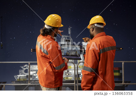 Drilling rig engineering team analyzing machinery performance on laptop dashboard screen. Offshore platform teamworking colleagues monitoring oil extraction rates and system pressure using notebook Drilling rig engineering team analyzing machinery performance on laptop dashboard screen. Offshore platform teamworking colleagues monitoring oil extraction rates and system pressure using notebook 136063358