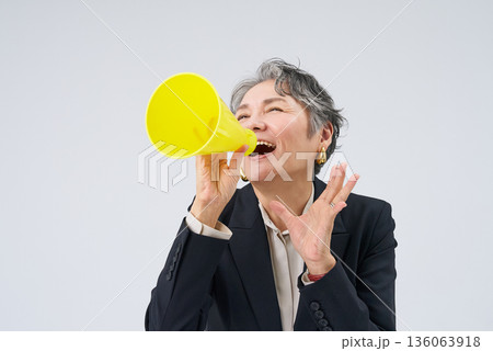 応援のポーズをするスーツ姿のシニア女性 136063918