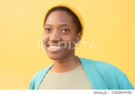 Closeup of happy young woman in cap against bright Closeup of happy young woman in cap against bright 136064490