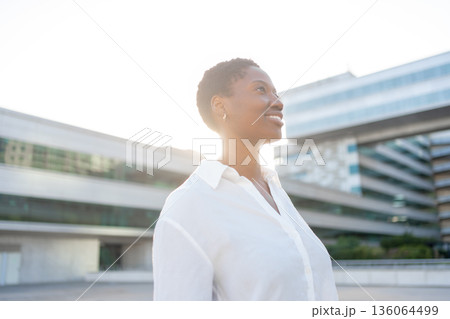 Thoughtful businesswoman in white shirt standing Thoughtful businesswoman in white shirt standing 136064499
