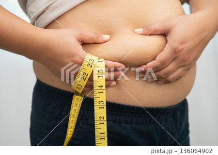 Asian woman with fat belly big size overweight and obesity with measure tape. Asian woman with fat belly big size overweight and obesity with measure tape. 136064902