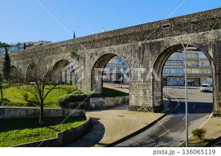 Historic stone aqueduct with arches in urban park sunny day blue sky ancient masonry architecture Portugal. High quality photo Historic stone aqueduct with arches in urban park sunny day blue sky ancient masonry architecture Portugal. High quality photo 136065119