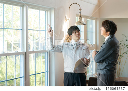 窓の前で打ち合わせする作業服の男性 窓の前で打ち合わせする作業服の男性 136065287