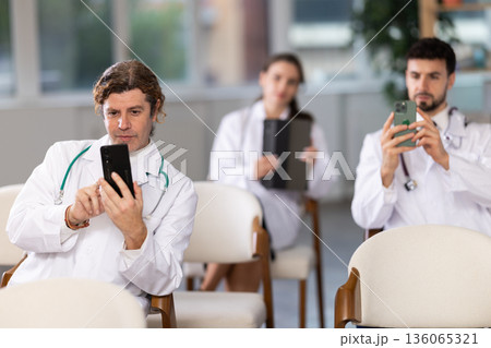 Medical students take pictures of information during meeting or lecture 136065321