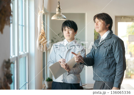 窓の前で打ち合わせする作業服の男性 窓の前で打ち合わせする作業服の男性 136065336