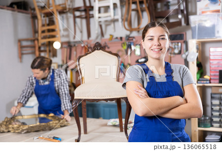 Happy young female furniture worker welcoming inside his workshop Happy young female furniture worker welcoming inside his workshop 136065518