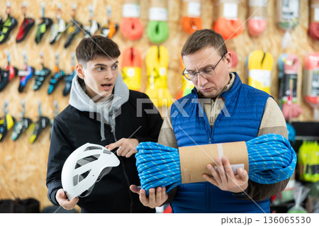 Guy with father chooses rope in store for long hikes Guy with father chooses rope in store for long hikes 136065530