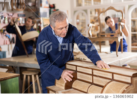 Senior male furniture workshop worker designing vintage chest of drawers Senior male furniture workshop worker designing vintage chest of drawers 136065902