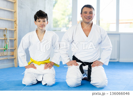 Man and boy teenager posing on floor in studio Man and boy teenager posing on floor in studio 136066046