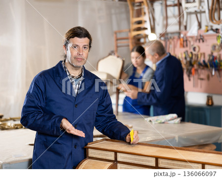 Male carpenter working on making vintage commode in workshop Male carpenter working on making vintage commode in workshop 136066097