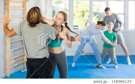 Teen girl in gym perform basic elements of krav maga self-defense system. 136066125