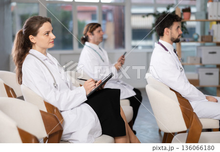 Medical students or doctors attending training session in modern lecture room 136066180