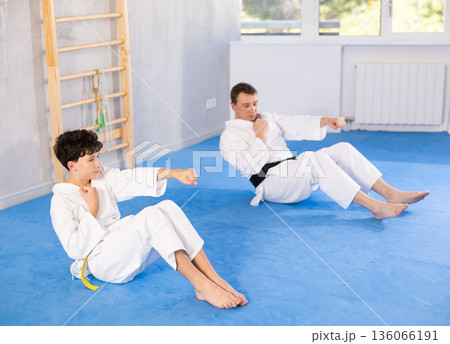 Man and boy teenager doing abdominal exercises 136066191