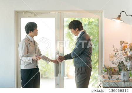 扉の建て付けをチェックする作業服の男性 扉の建て付けをチェックする作業服の男性 136066312