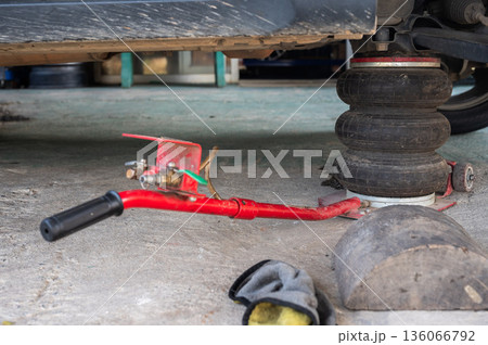 Close up of a pneumatic jack while using. Pneumatic jacks are powered by compressed air and are used for lifting and positioning heavy material and machinery effortlessly. Close up of a pneumatic jack while using. Pneumatic jacks are powered by compressed air and are used for lifting and positioning heavy material and machinery effortlessly. 136066792